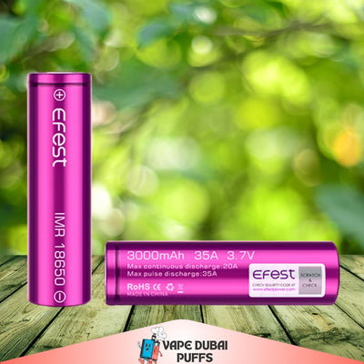 Pink Efest 18650 3000mah 35A battery on a wooden surface with a green blurred background