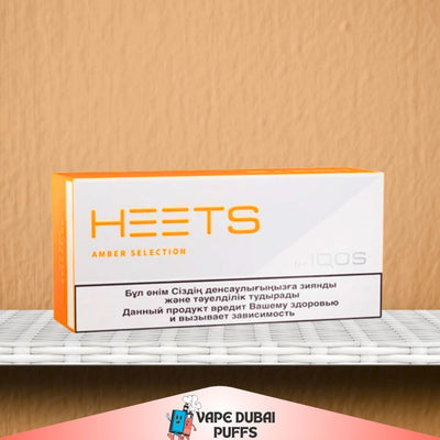 IQOS HEETS Ambar Selection packaging on a shelf with a beige wall background