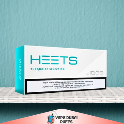 IQOS HEETS turquoise selection packaging on a shelf with a blue wall background